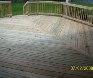 A newly built wooden deck with railings, featuring geometric plank patterns and a lawn in the background. Dated July 2, 2008.